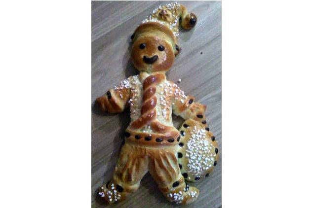 Weihnachtsmänner und Mohnschnecken Hefeteigweihnachtsmann mit einem Sack voller Süßigkeiten, mit Hagelzucker und Schokoladentröpfchen dekoriert.
